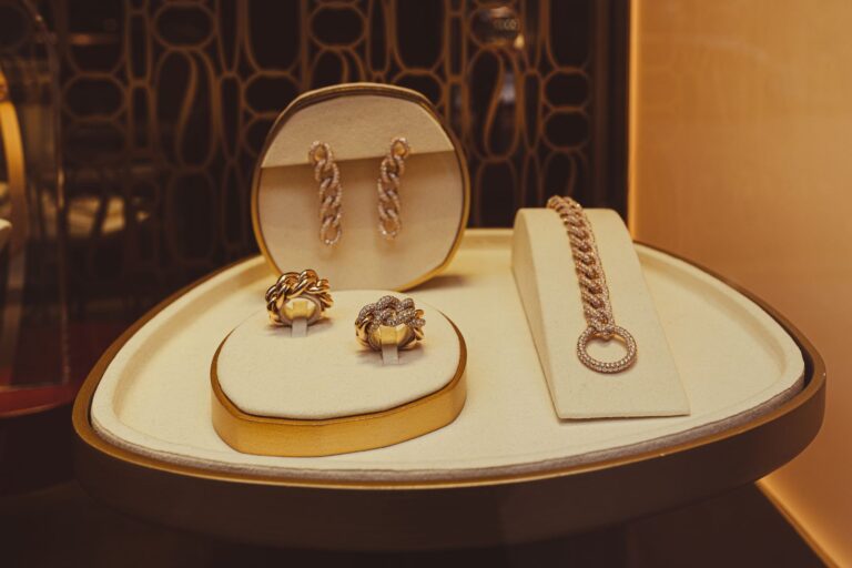 Expositor con pendientes, anillos y una pulsera dorados (imagen de referencia de joyería y relojería)